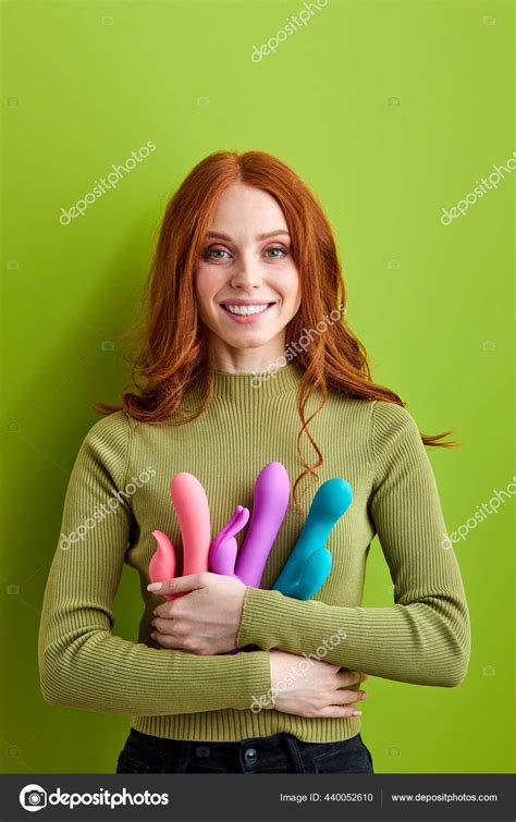 Smiling redhead woman gets pleasure using sex toys vibrator to satisfy ...