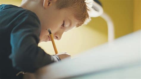 男孩(10-11)在书桌上做作业的特写视频素材_ID:VCG42825086794-VCG.COM