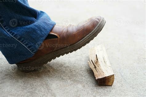 Closeup man wears shoes is stepping on rusty metal nail on wood. Concept, unsafe , risk for ...