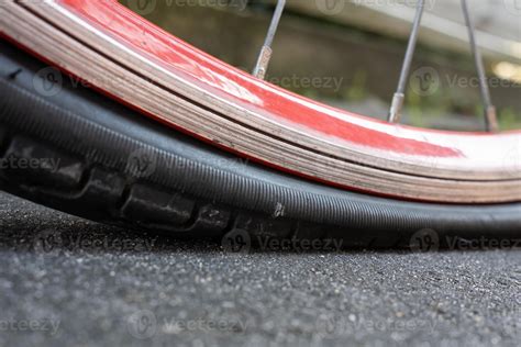 Punctured bicycle wheel, with a deflation tire on the pavement. Bike repair. Bottom view ...