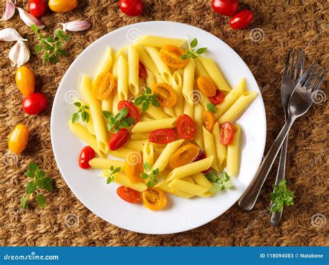 Penne Pasta with Yellow and Red Tomatoes Decorated with Basil on Sisal ...