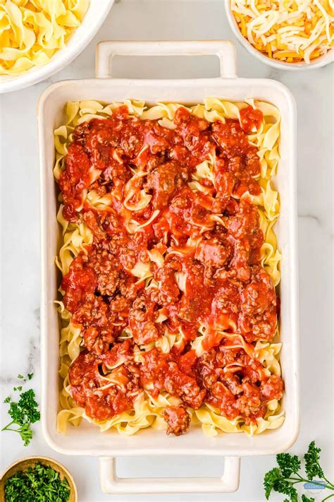 top-down view of a white 9x13 casserole dish of Grandmaâ��s ground beef casserole with a scoop out a