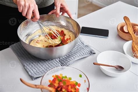 Woman in kitchen cooking a cake. Hands beat the dough with mixer ...