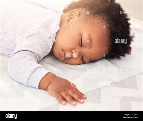 Sleeping Like a Baby. a little baby boy sleeping on a bed Stock Photo ...