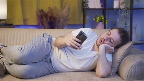 Man falling asleep at night with phone in hand. Phone addiction. 32966573 Stock Video at Vecteezy