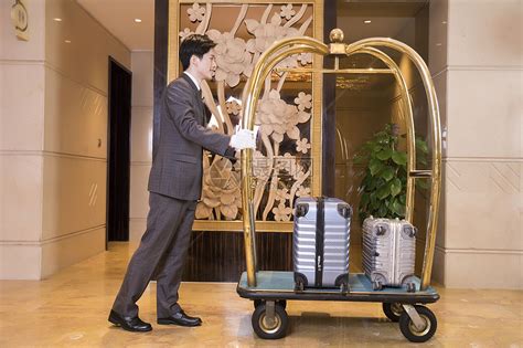 酒店服务员为顾客搬运行李高清图片下载-正版图片501203452-摄图网