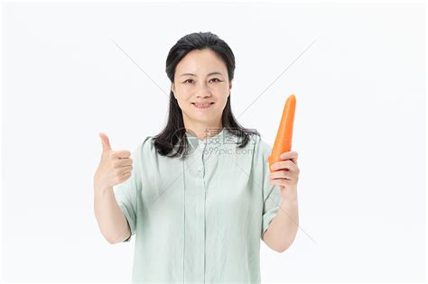 中年女性手拿胡萝卜高清图片下载-正版图片501378620-摄图网