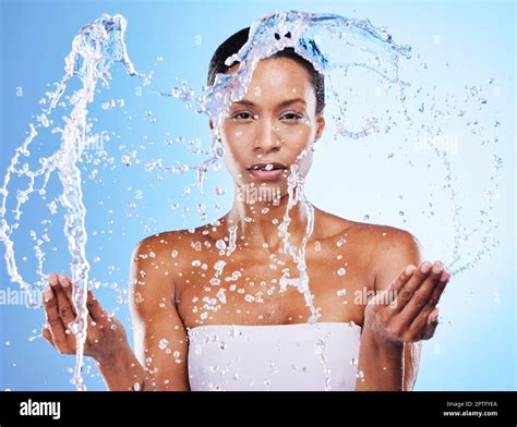 Clean, beauty and water splash with black woman in shower and grooming portrait against blue ...