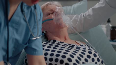 Doctor putting oxygen mask on face of hyperventilating patient ...