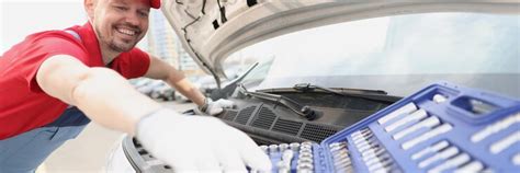 Automotive technician smiling and take instrument from open kit ...