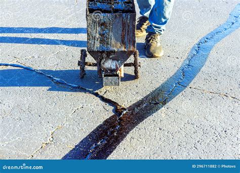 An Asphalt Patcher Performs Coated Filling Asphalt Cracks Sealing ...