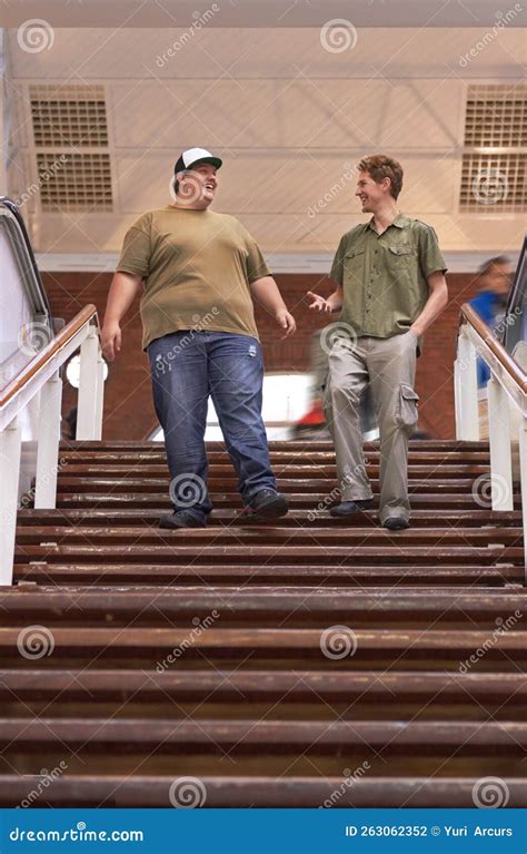 Stepping Out. Two Young Men Walking Down a Flight of Stair Together ...