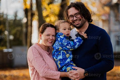 en un soleado otoño día en el parque, un madre y padre cariñosamente ...