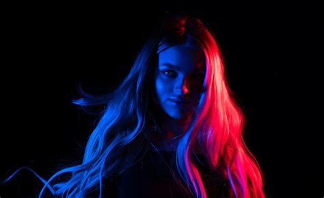 Portrait of fashion young girl in red and blue neon light in the studio ...