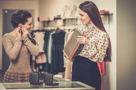 Female shop assistant at check-out - Stock Photo - Dissolve