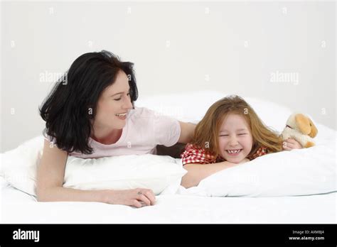 Mother and daughter cuddling on a bed in a kids room
