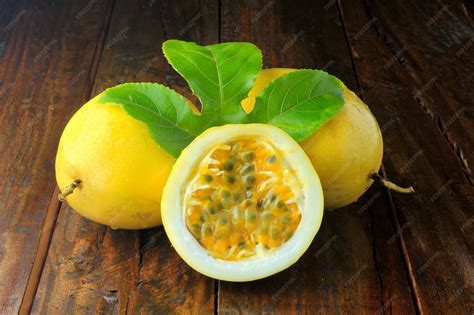 Yellow passion fruit with leaf and passion fruit cut in half on wooden ...