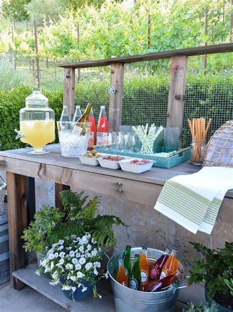 https://i.shelterness.com/2019/03/12-a-rustic-meets-vintage-drink-station-with-potted-greenery-and-blooms-and-a-wire-backdrop-plus-a-bucket-with-bottles.jpg