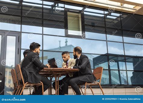 Business People Colleagues Sit at a Table on the Street and Talk ...