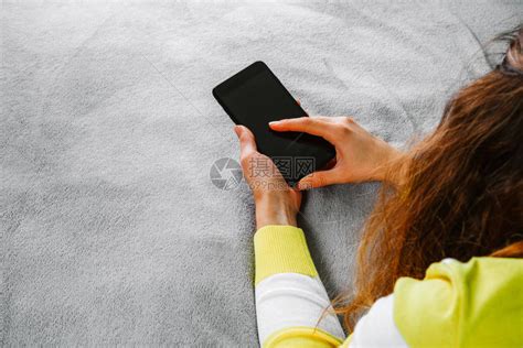 女人躺在床上手拿着智能手机高清图片下载-正版图片504084708-摄图网