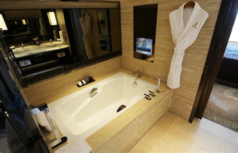 The Ritz-Carlton bath mat hung over standing bathtub