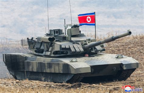 North Korea's Kim 'drives' new tank during mock battle | Reuters