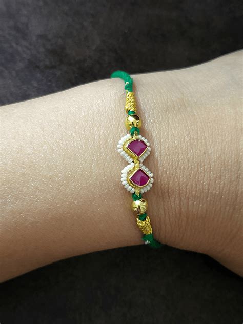 Ruby triangular stones pirohi work green thread rakhi – Odara Jewellery