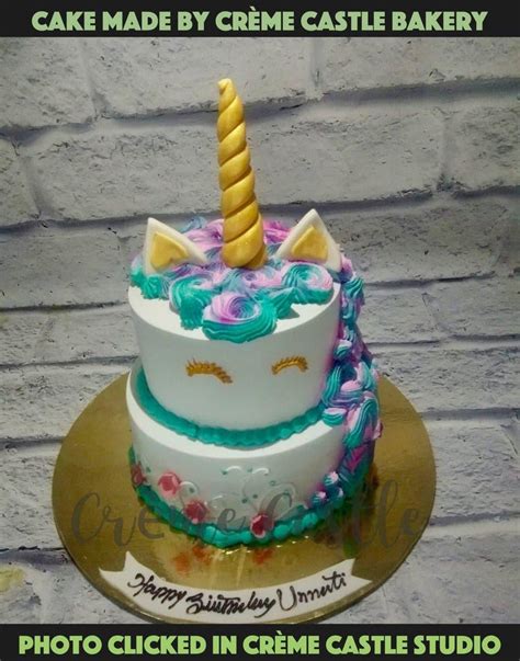 A unicorn theme tier cake with a golden horn on top and rest cake in ...