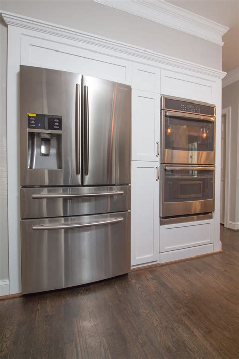 a stainless steel refrigerator and oven in a kitchen with white ...