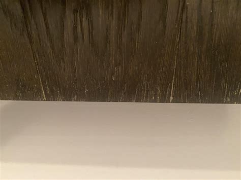 How do I clean this?An edge in my bathroom, hardwood floor. The edges ...