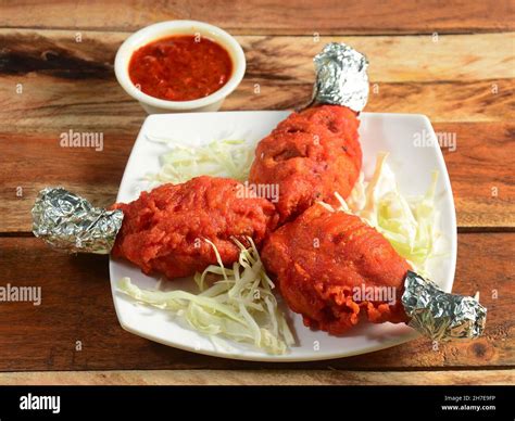 Tasty and spicy deep fried Chicken drumstick served on wooden ...