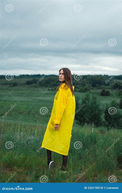 Back View of a Female Traveler in a Yellow Raincoat Stock Photo - Image ...