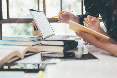 Premium Photo | Cropped image of students using laptop while studying ...