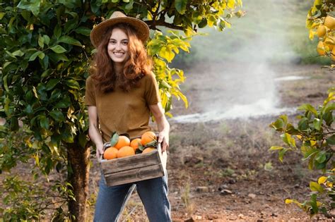 Eine Frau hält einen Korb mit Orangen | Kostenlose Foto