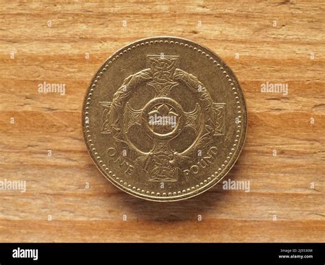one pound coin reverse side showing Celtic cross with pimpernel flower and torc representing ...