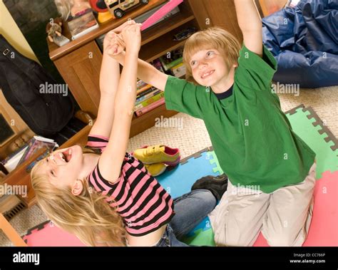 Twins wrestling and tickling in their playroom Stock Photo - Alamy