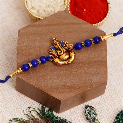 Golden Lord Ganesha Blue Pearl Rakhi and Roli Chawal Pack - eCraftIndia ...