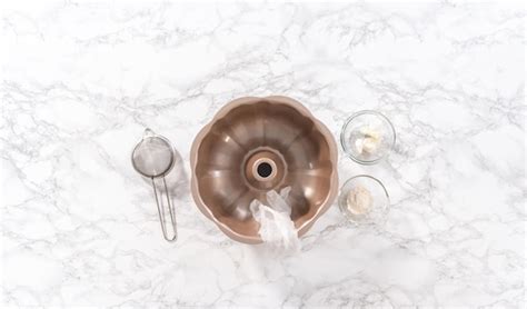 Flat lay. greasing bunt cake pan to bake chocolate pumpkin bundt cake ...