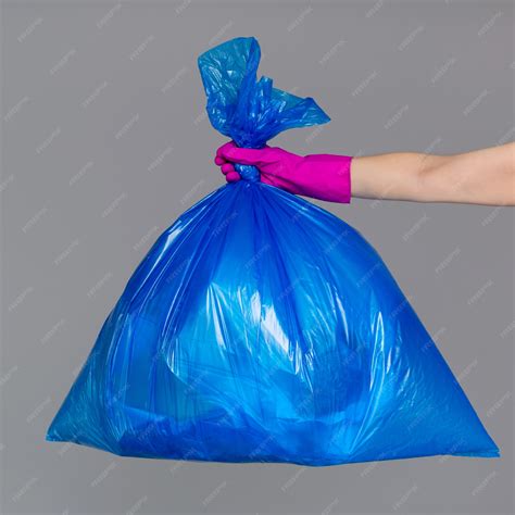 See related image detail. Premium Photo | Hand in a rubber glove holds a blue plastic bag full of ...