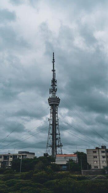 Communications tower in city agnst cloudy sky | Premium AI-generated image