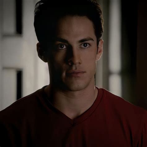a man in a red shirt looking at the camera with an intense look on his face