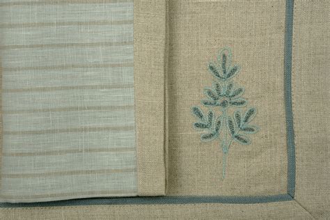 Natural coloured embroidered linen placemats and blue and natural stri ...