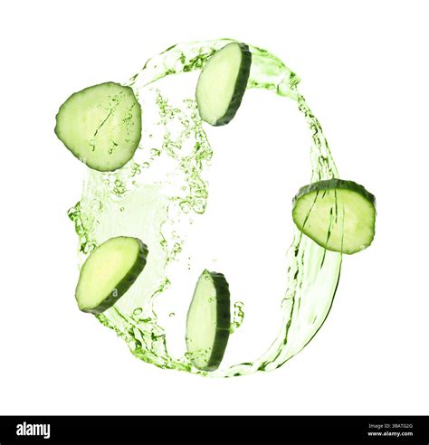 Cucumber slices and splashing green liquid in air on white background ...