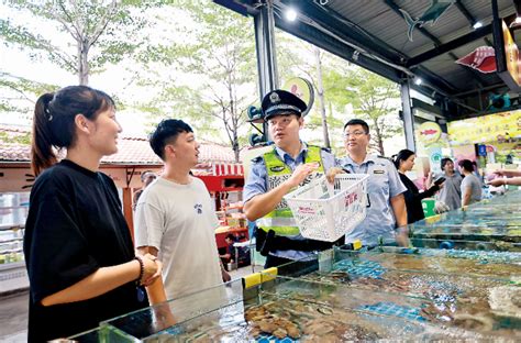 8月3日，三亚市公安局旅游警察支队民警向游客展示如何使用“诚信筐”。