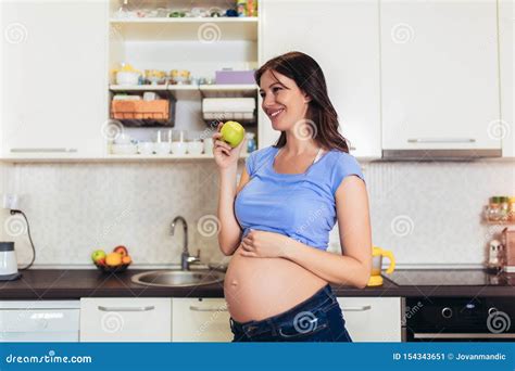 Pregnant Woman Eating an Apple at Home in the Kitchen Stock Image - Image of freshness, domicile ...