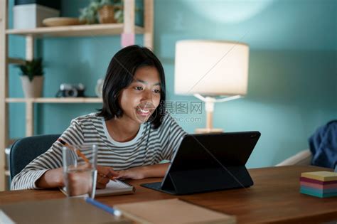 在家工作沟通上学的亚裔女孩做功课晚上和在平板电脑办公桌上的教师一起在线学习坐着高清图片下载-正版图片307992298-摄图网