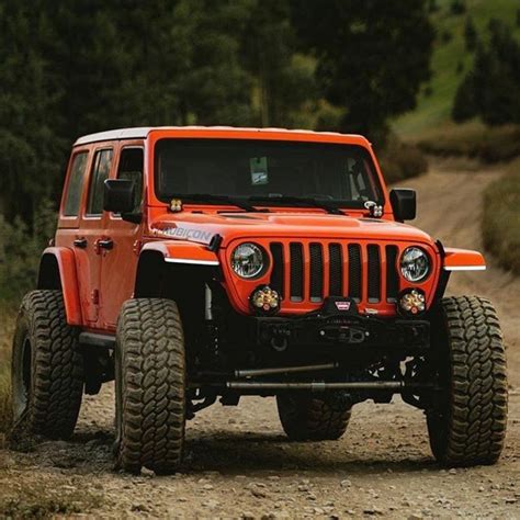 Orange Jeep Driving Down a Dirt Road