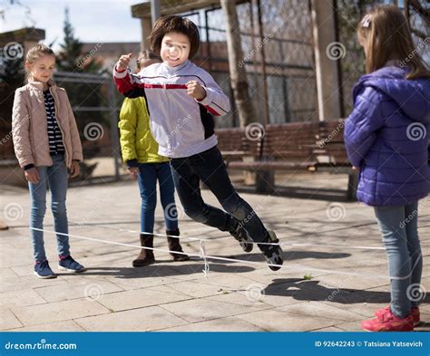 Active Children`s Games. Boy Jumps Over the Rope Stock Image - Image of ...