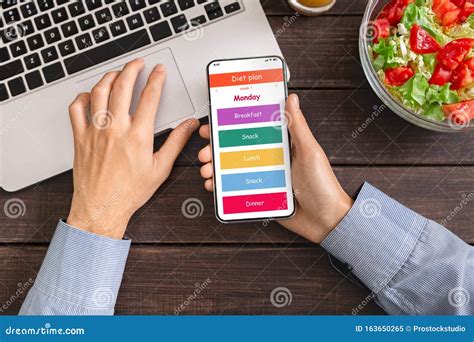 Man Using Laptop and Smartphone with daily Diet Plan Application Stock ...