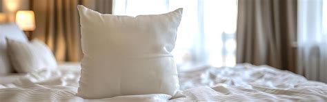 JW Marriott bed in hotel room with logo on an accent pillow